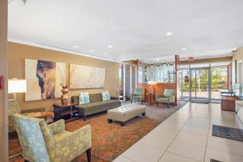 a living room with a couch and chairs and tables at Forest Park Hotel in Clifton Heights