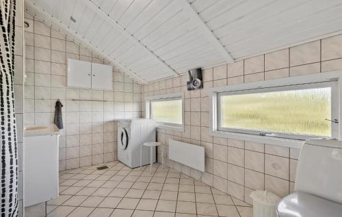 bagno piastrellato con lavandino e frigorifero. di Cozy Home In Hvide Sande With Wifi a Bjerregård
