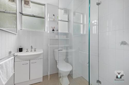 a white bathroom with a toilet and a sink at KozyGuru Redfern Charming 1 Bed Parking NRE012 in Sydney