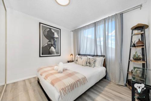a bedroom with a bed and a large window at KozyGuru Redfern Charming 1 Bed Parking NRE012 in Sydney