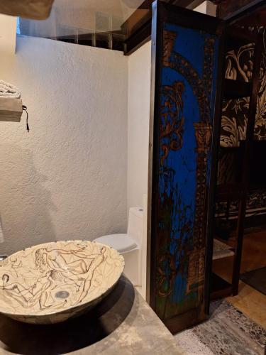a bathroom with a toilet and a glass door at Quinta Ascensión Hotel Boutique Only Adults in Malinalco