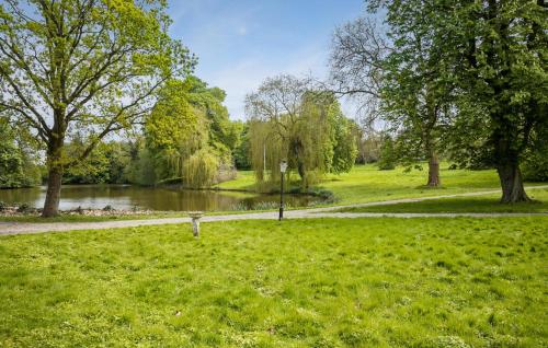 a path through a park with a pond and trees at 1 Bedroom Nice Home In Faaborg in Fåborg