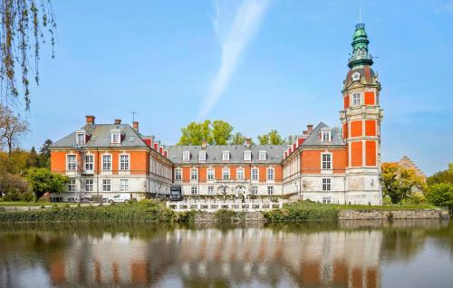 a large building with a clock tower next to a lake at 1 Bedroom Nice Home In Faaborg in Fåborg