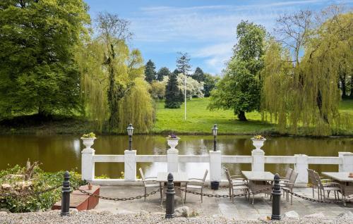 a white fence with tables and chairs next to a pond at 1 Bedroom Nice Home In Faaborg in Fåborg