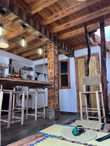 a kitchen with wooden ceilings and a table and chairs at Essaouira wood house in Essaouira