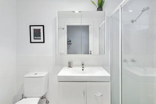 y baño con aseo, lavabo y ducha. en Contemporary 1-Bed Apartment Moments from MCG en Melbourne