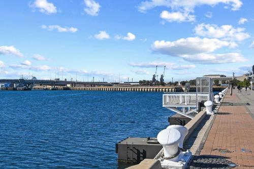 a row of benches next to a body of water at Jolly Jubilant Jubilee in Port Adelaide
