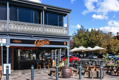 a restaurant with tables and chairs in front of a building at Jolly Jubilant Jubilee in Port Adelaide