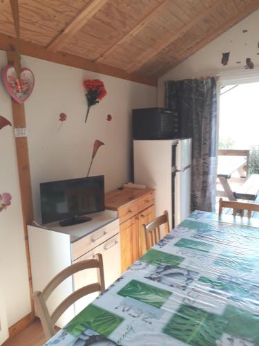 une cuisine avec une table et un réfrigérateur dans l'établissement Chalet jolie vue montagne Air vivifiant, à Saint-Léger-les-Mélèzes