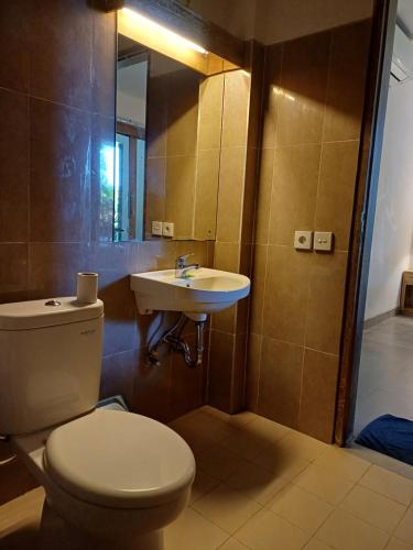 a bathroom with a toilet and a sink at Blu Mango in Ubud