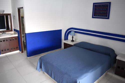 a bedroom with a blue bed and a sink at Hotel Plaza Almendros, Isla Mujeres in Isla Mujeres