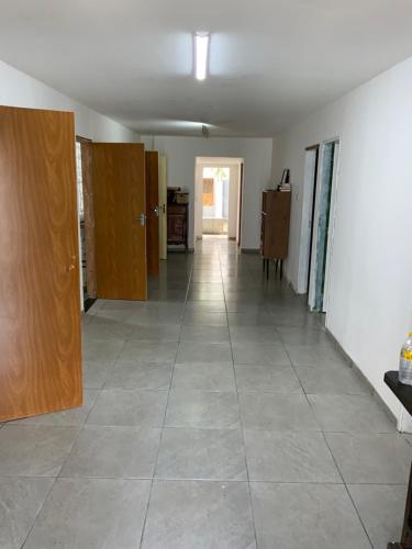 um corredor vazio com portas de madeira e piso em azulejo em HOSTEL DO PORTO em Porto de Galinhas