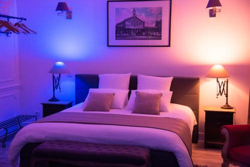 a bedroom with a large bed with purple lighting at Chic Appart - Sauna privatif in Tourcoing