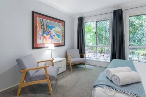 a bedroom with a bed and two chairs and a window at Family Escape - Serene Oasis with Pool and AC in Brisbane