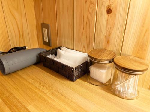 a bathroom with a toilet and a trash can at 古民家ホテル 結 YUWAI in Hakuba