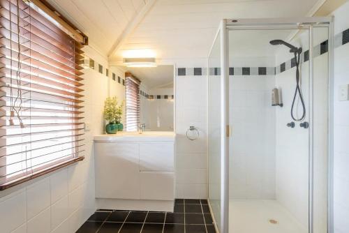 La salle de bains est pourvue d'une douche et d'un lavabo. dans l'établissement Elegant 4-Bedroom Residence with Entertaining Area, à Brisbane