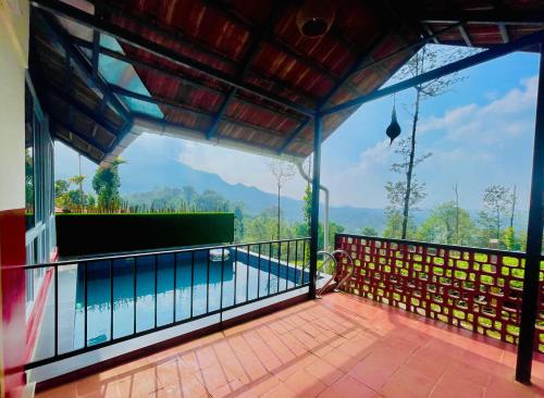 a view from the balcony of a house with a swimming pool at Mayflower Holiday Villa in Meppādi