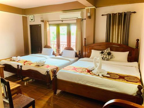 um quarto com 2 camas e uma janela em Happy Riverview Hotel em Vang Vieng