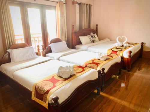 um quarto com três camas com arcos em Happy Riverview Hotel em Vang Vieng