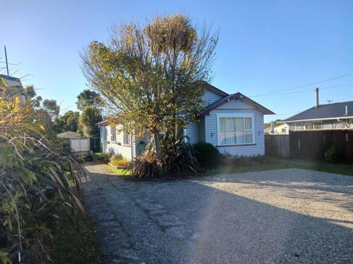 a house with a tree on the side of a driveway at Charming House in Westport in Westport