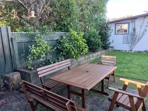 a picnic table and two benches in a backyard at Charming House in Westport in Westport