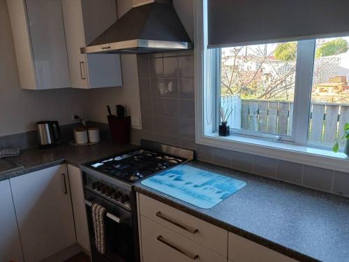 a kitchen with a stove top oven next to a window at Charming House in Westport in Westport