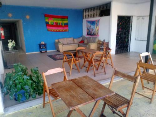 una sala de estar con mesas y sillas de madera. en Histórico Hotel, en Salvador