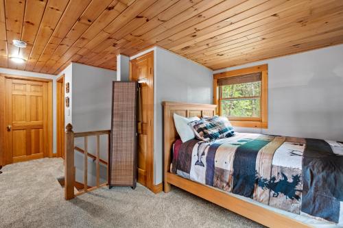 - une chambre avec un lit et un plafond en bois dans l'établissement Private Lakefront! - Luxury Log House!, à Sanbornton