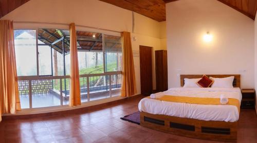 a bedroom with a bed and a large window at Mayflower Holiday Villa in Meppādi