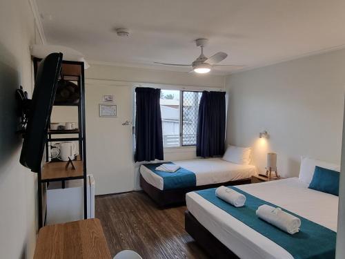 a room with two beds and a bunk bed at Bargara Beach Hotel in Bargara