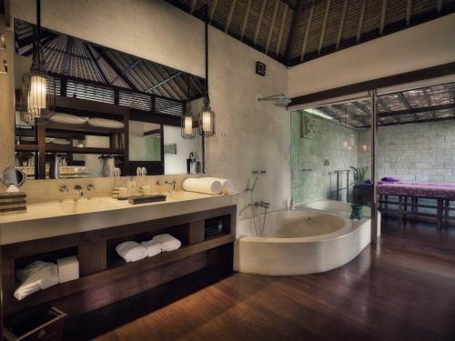 a large bathroom with a tub and a sink at Hanging Gardens of Bali in Payangan