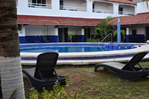 two chairs in front of a swimming pool at Hotel Plaza Almendros, Isla Mujeres in Isla Mujeres