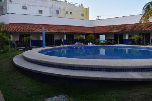 a large swimming pool in front of a building at Hotel Plaza Almendros, Isla Mujeres in Isla Mujeres