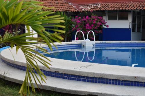 a swimming pool with two chairs in a house at Hotel Plaza Almendros, Isla Mujeres in Isla Mujeres