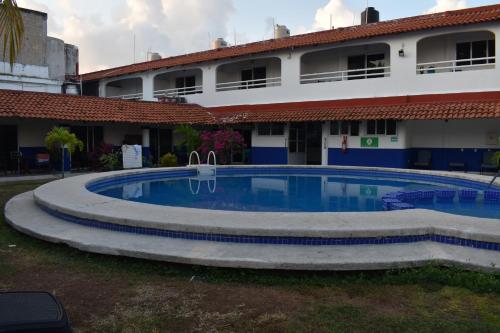 a swimming pool in front of a building at Hotel Plaza Almendros, Isla Mujeres in Isla Mujeres