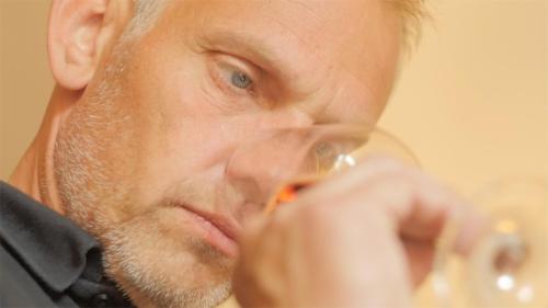 a man brushing his teeth with an orange toothbrush at Hotel / Weingut Meintzinger in Frickenhausen