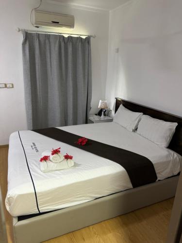 a bedroom with a large bed with red roses on it at Airport Ace Hotel in Nadi