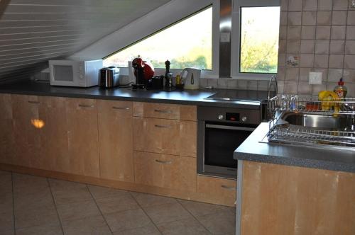 a kitchen with a sink and a microwave at Studio de Vacances Philipona in Granges