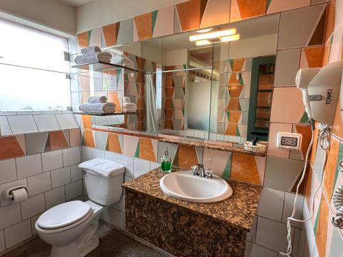 uma casa de banho com um WC, um lavatório e um espelho. em Collacocha B&B em Lima