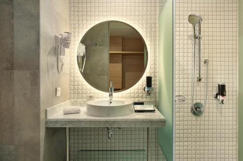 a bathroom with a sink and a mirror at Holiday Inn Express Jakarta Wahid Hasyim by IHG in Jakarta