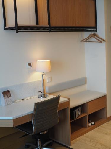 an office with a desk with a lamp and a chair at JEN Singapore Orchardgateway by Shangri-La in Singapore