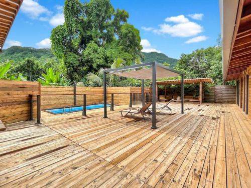 une terrasse en bois avec un kiosque et une piscine dans l'établissement Shared Pool King Bed & Air-Conditioned Cozy Apartment, à Vaïare