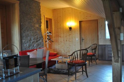 a living room with a couch and a table and chairs at Studio de Vacances Philipona in Granges