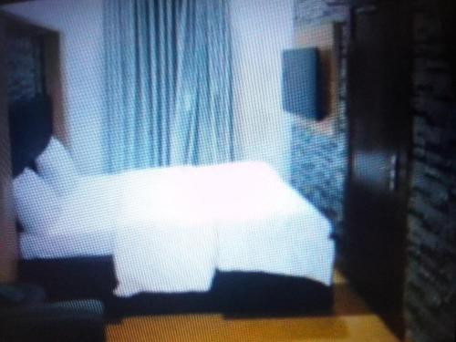 a bedroom with a white bed in front of a window at Exclusive mansion hotel and suites Lagos in Ilado