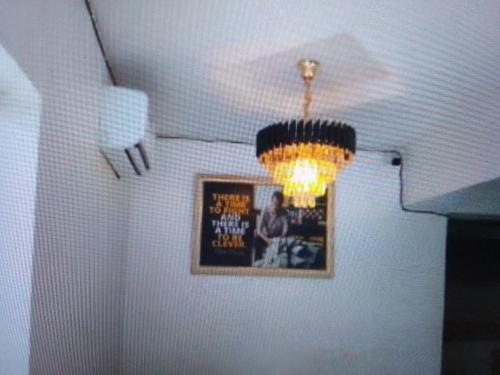 una lámpara de araña en una habitación con una foto en la pared en Exclusive mansion hotel and suites Lagos en Ilado