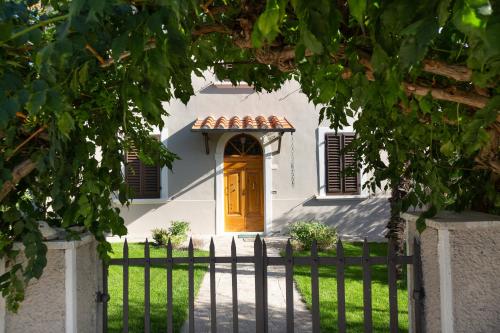 a white house with a brown door and a fence at A Casa di Franca Villa con piscina in Gambassi Terme