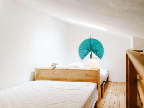 - une chambre avec un lit et un ventilateur bleu dans l'établissement T2 Mezzanine Climatisé Rénové - Plage des Chalets, Gruissan - 6 Pers, Parking, WiFi Option - FR-1-409-174, à Gruissan
