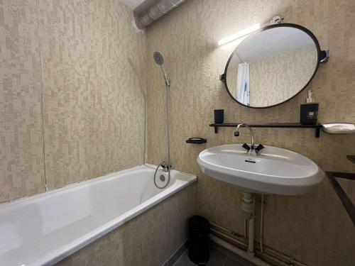 une salle de bain avec un lavabo, une baignoire et un miroir dans l'établissement Appartement avec parking à Gruissan, 4 couchages, proche plage - FR-1-229-886, à Gruissan