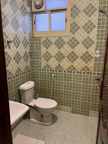 a bathroom with a toilet and a tub and a window at دار الرضا Dar Al Reda in Medina
