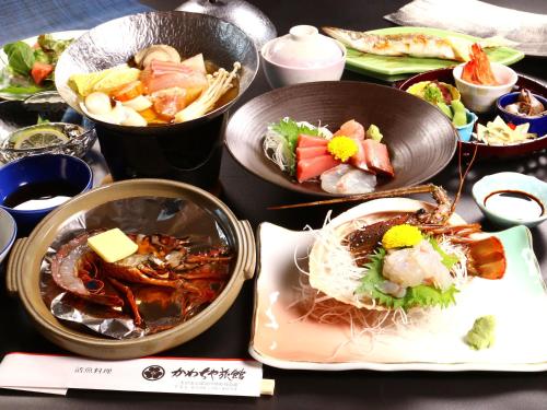 a table with plates of food and bowls of food at Kawachiya Ryokan in Minamiise